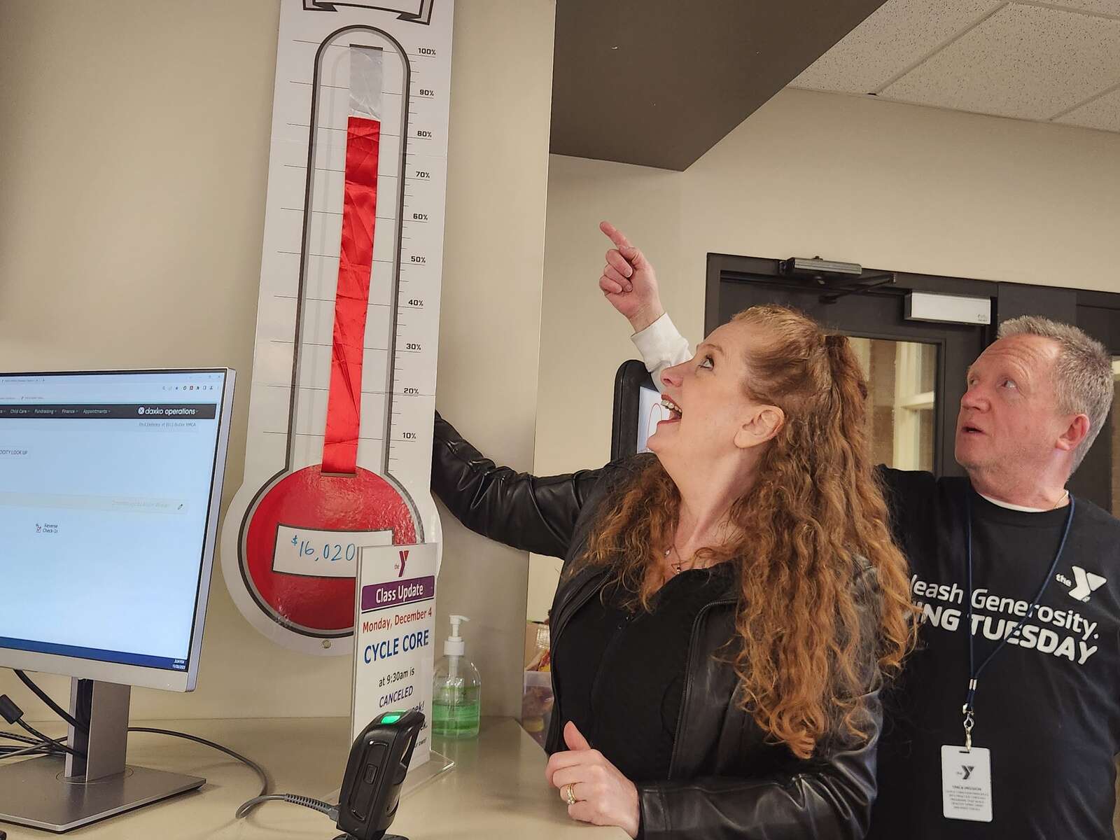 Butler YMCA staff update a thermometer tracking money raised