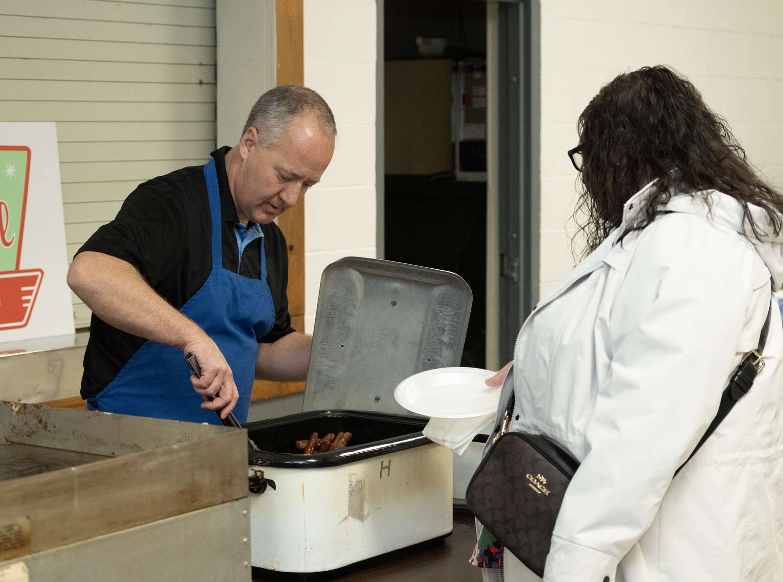 Dave White,  president of Butler Rotary Club PM, serves up sausages