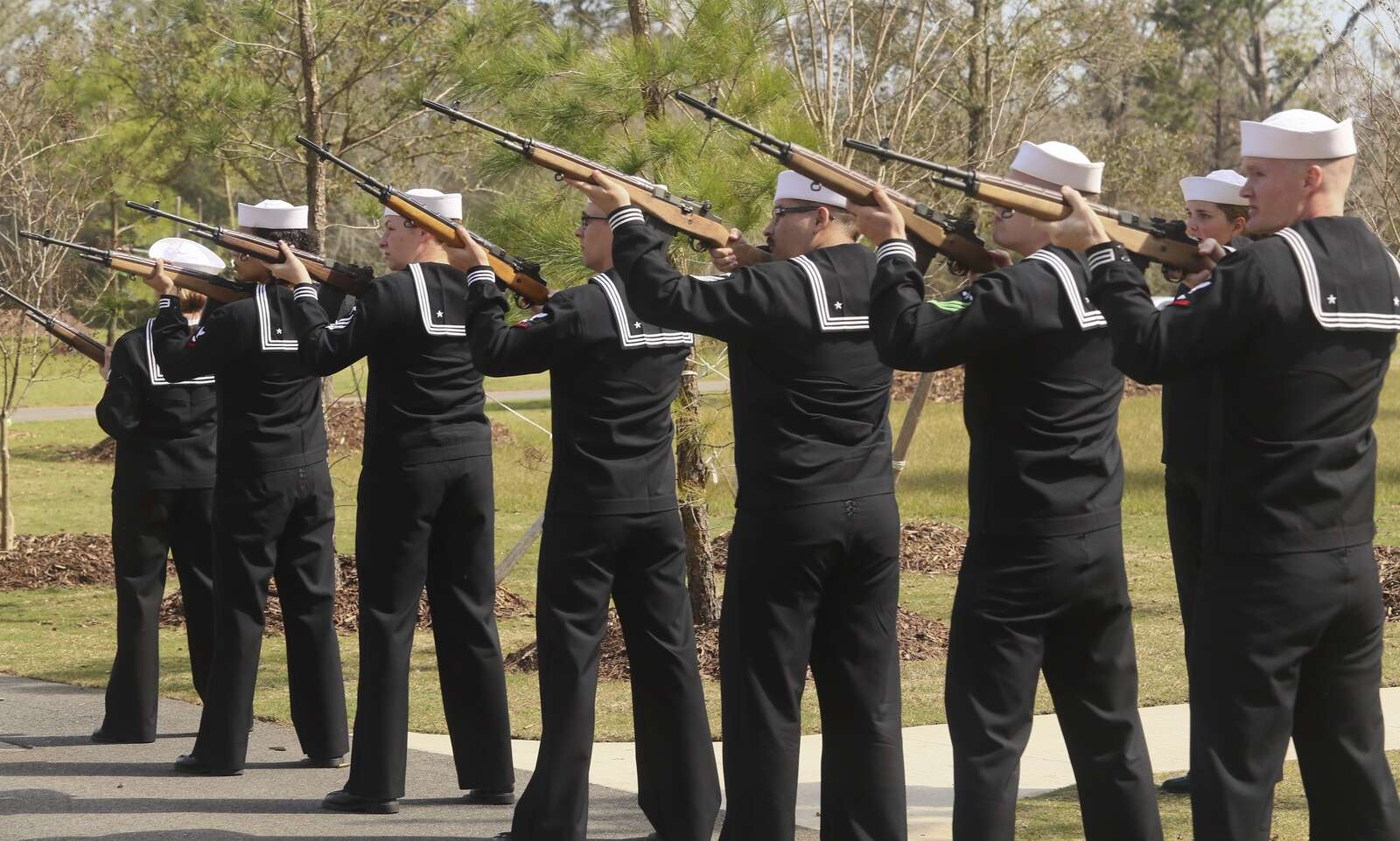 Navy Operational Support Center members perform a 21-gun salute