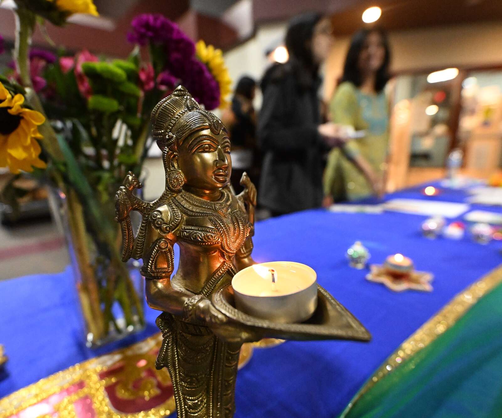 A Indian princess statue holds a candle