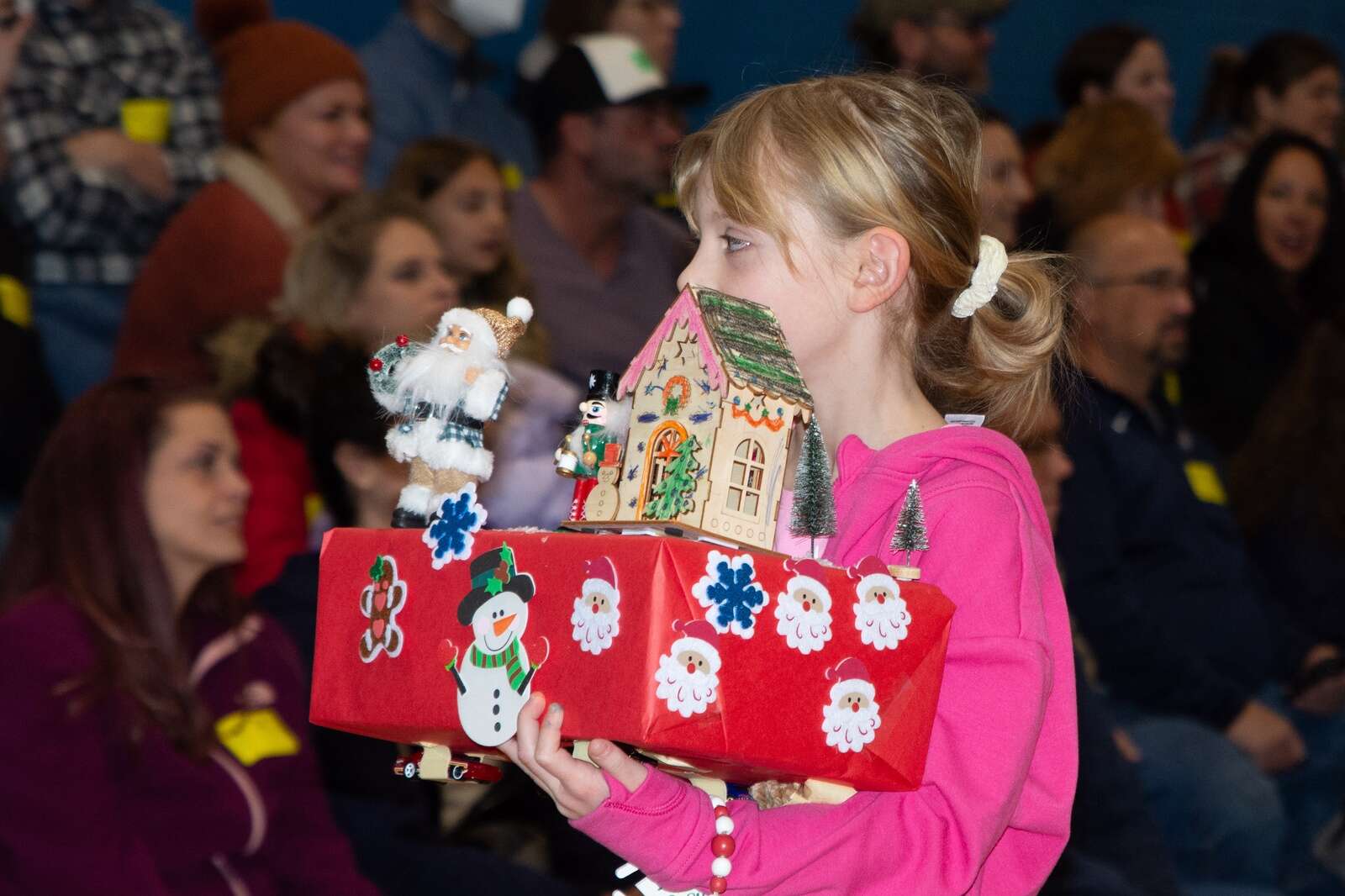 Student at Knoch Primary School holds up her Christmas themed float