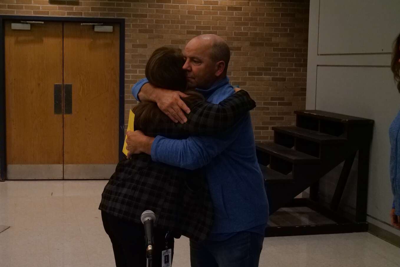 Linda Andreassi shares a hug with departing school board member Jim Nickel