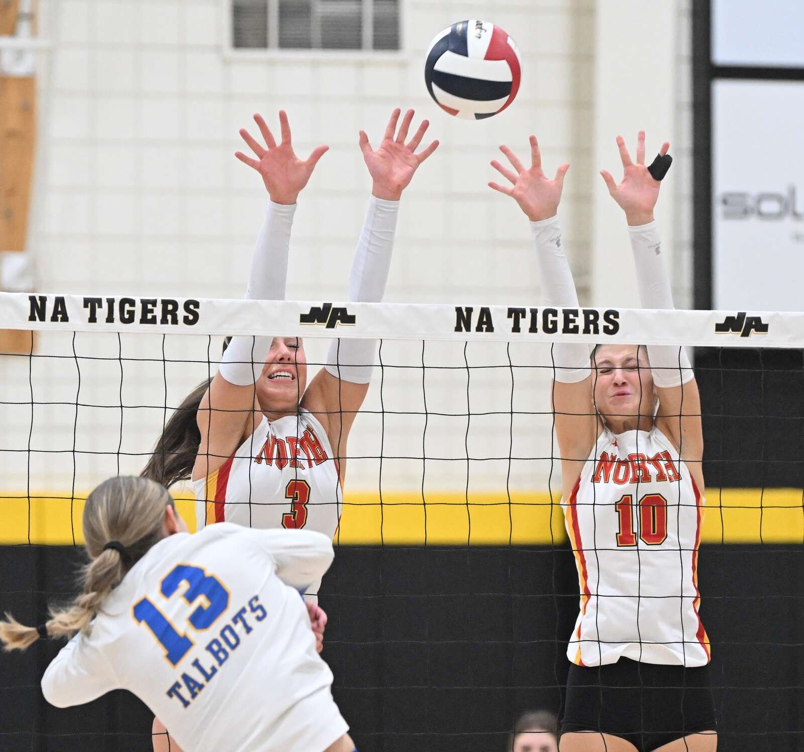 North Catholic’s Sienna Cozza  and Claire Beaman try to block a kill attempt by Hampton’s Emerson Schrom