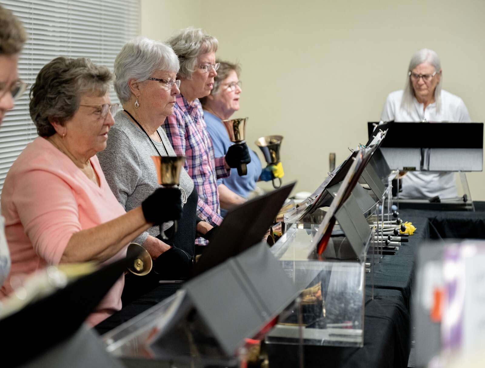 Members of A Circle of Friends bell choir concentrate as they rehearse