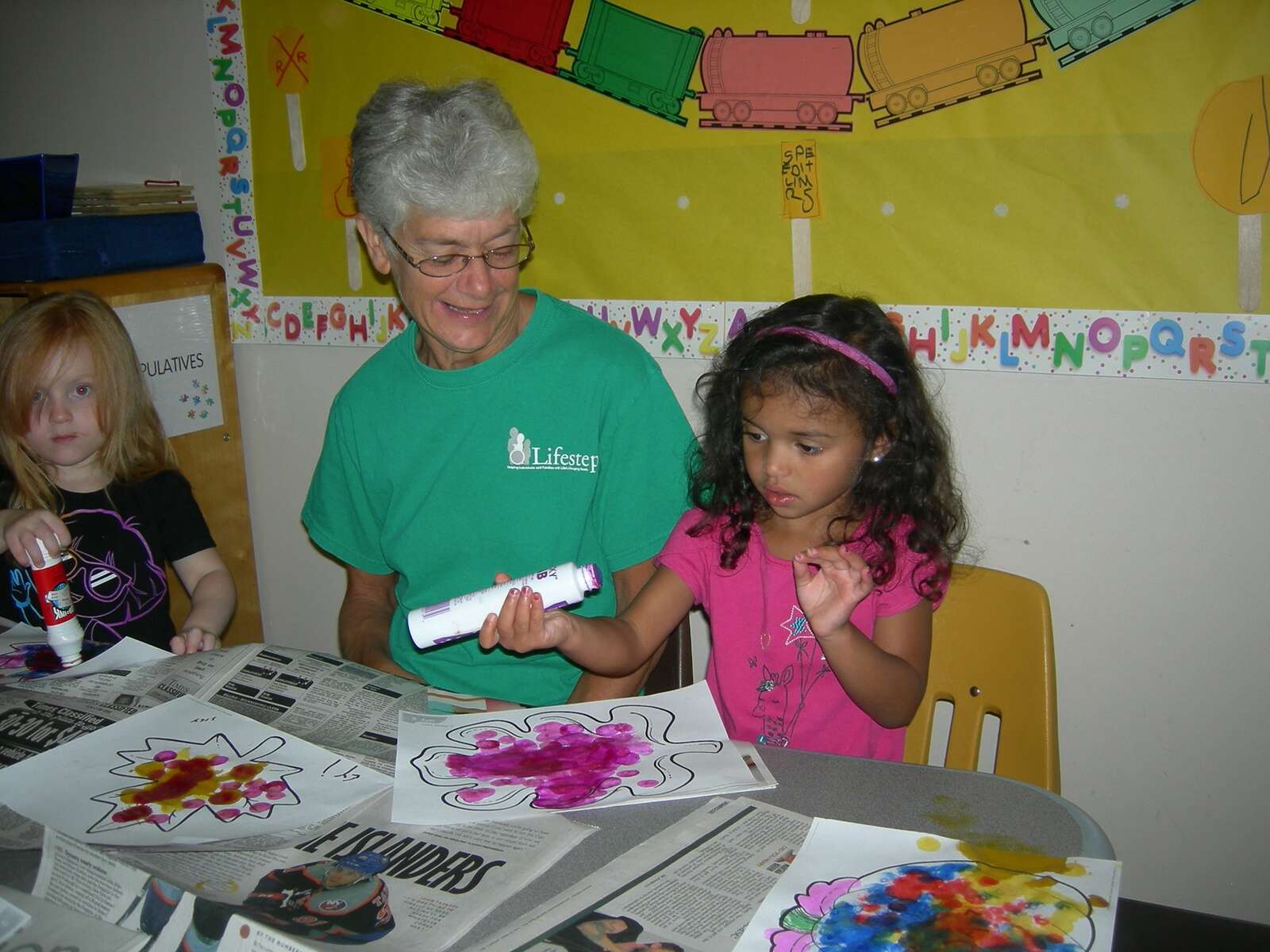 Diana Garmen  helps children with a craft at Lifesteps