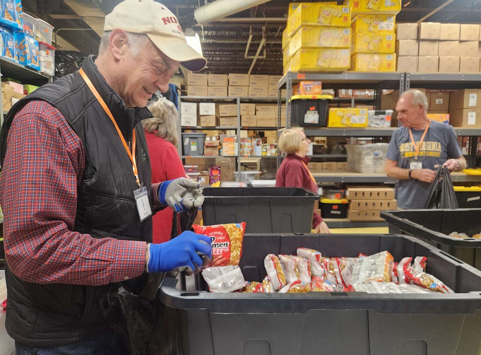Jim Smith places a packet of Top Ramen into a bag for the Kids’ Weekend Backpack Program