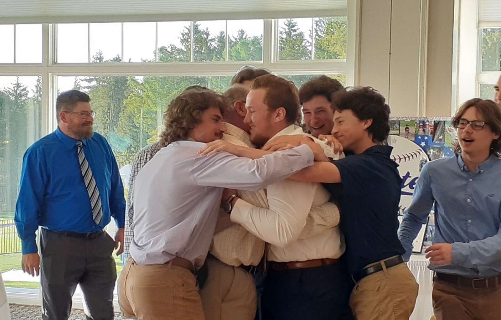 Members of the Knoch baseball team embrace coach Bill Stoops at their end-of-season banquet. From left to right are: Angelo DeLeonardis, Bill Stoops, Eli Sutton, and Dathan Gillis. Submitted photo